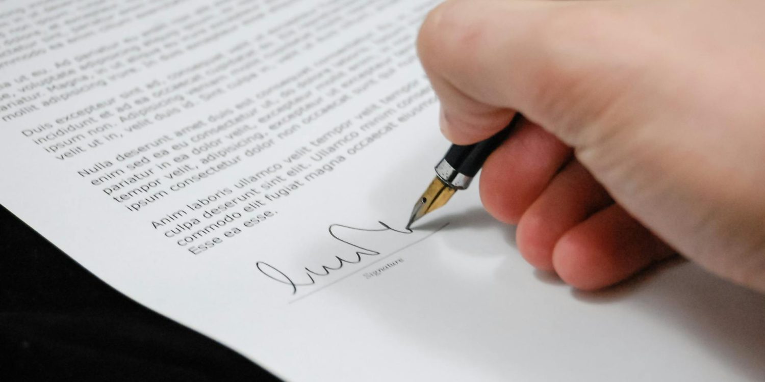 person signing in documentation paper