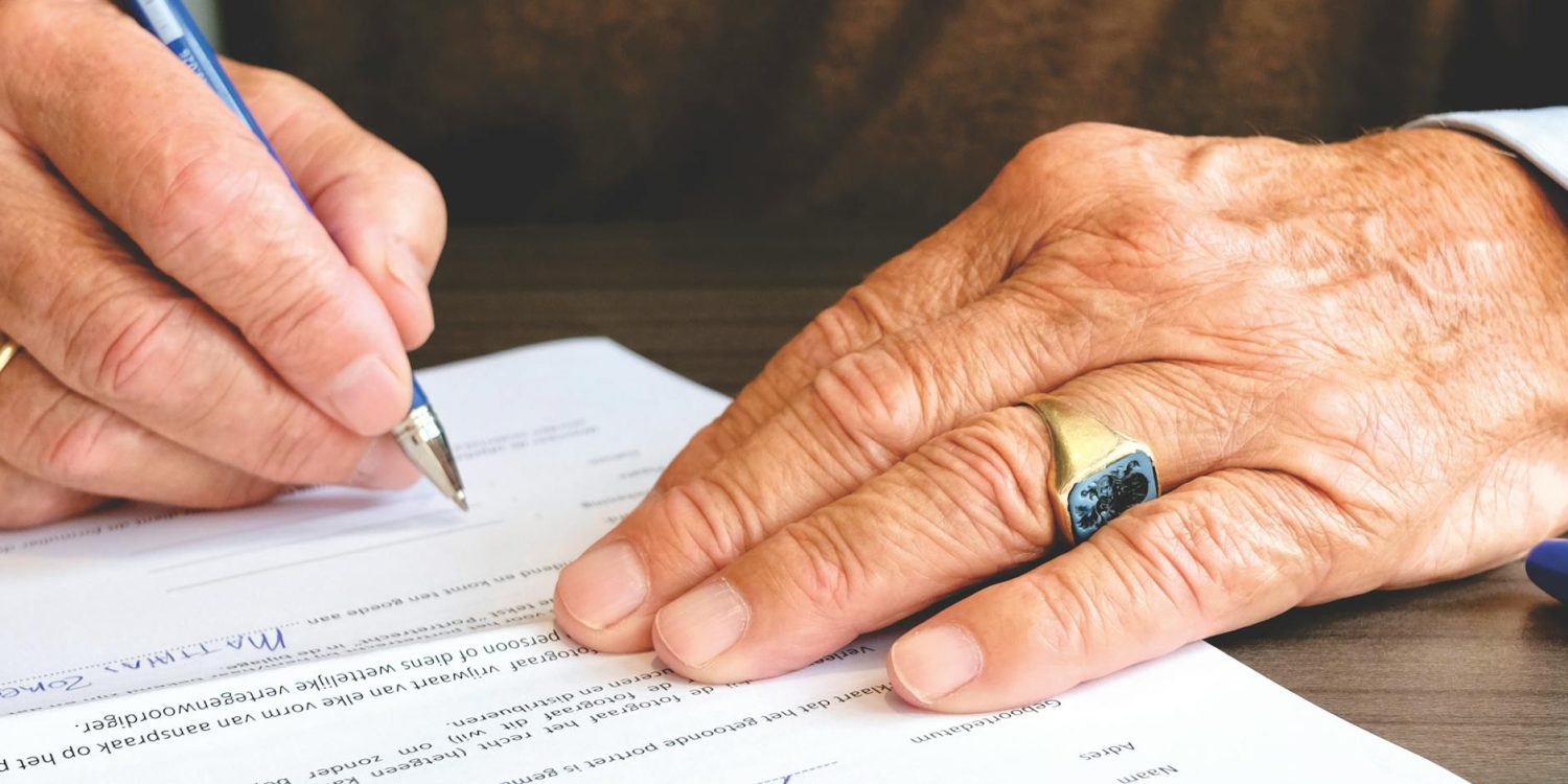 person signing document paper